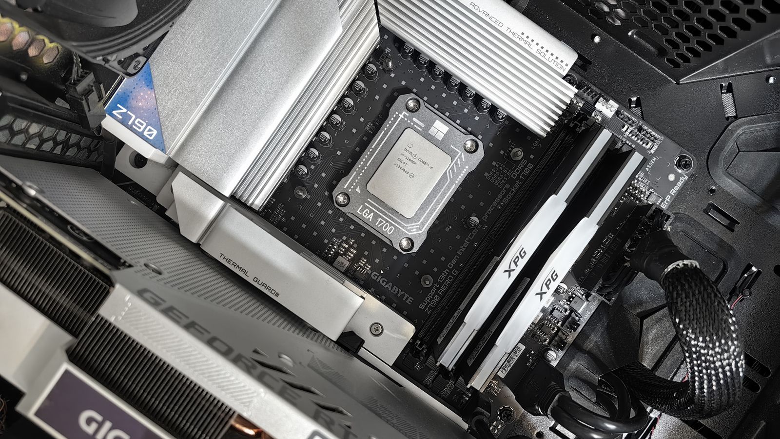 Close-up of a PC motherboard CPU socket with memory and a graphics card installed