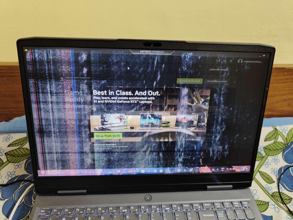 A Lenovo laptop screen showing vertical lines and flickering across the display