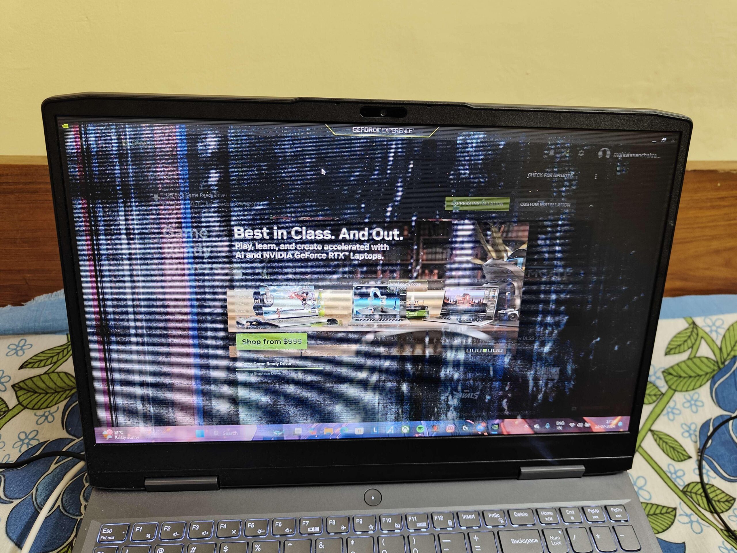 A Lenovo laptop screen showing vertical lines and flickering across the display