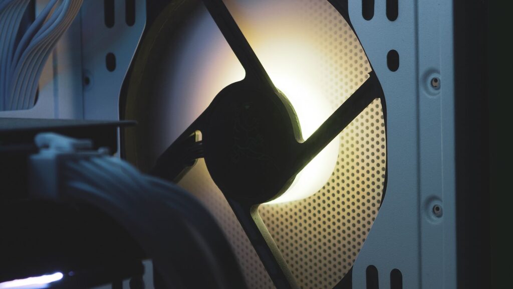 An illuminated case fan behind a mesh front panel for airflow