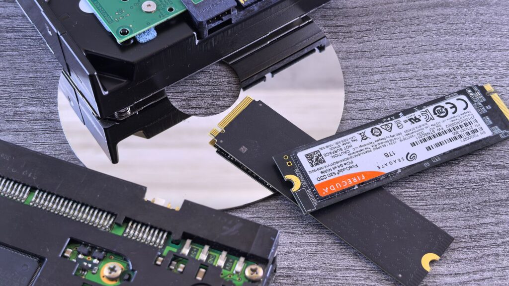 An M.2 NVMe SSD beside an opened mechanical hard drive