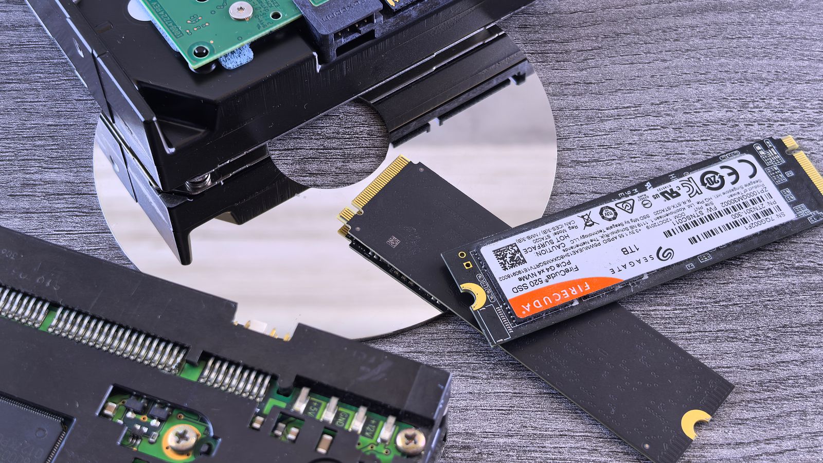 An M.2 NVMe SSD beside an opened mechanical hard drive