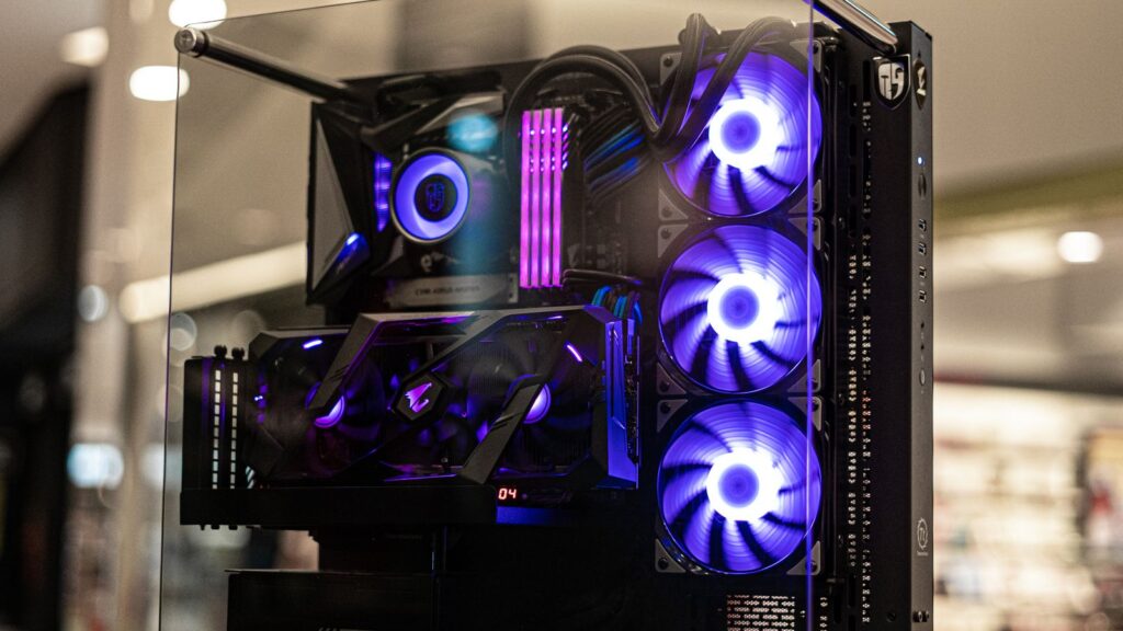 A gaming PC build with RGB cooling fans visible through a tempered glass case
