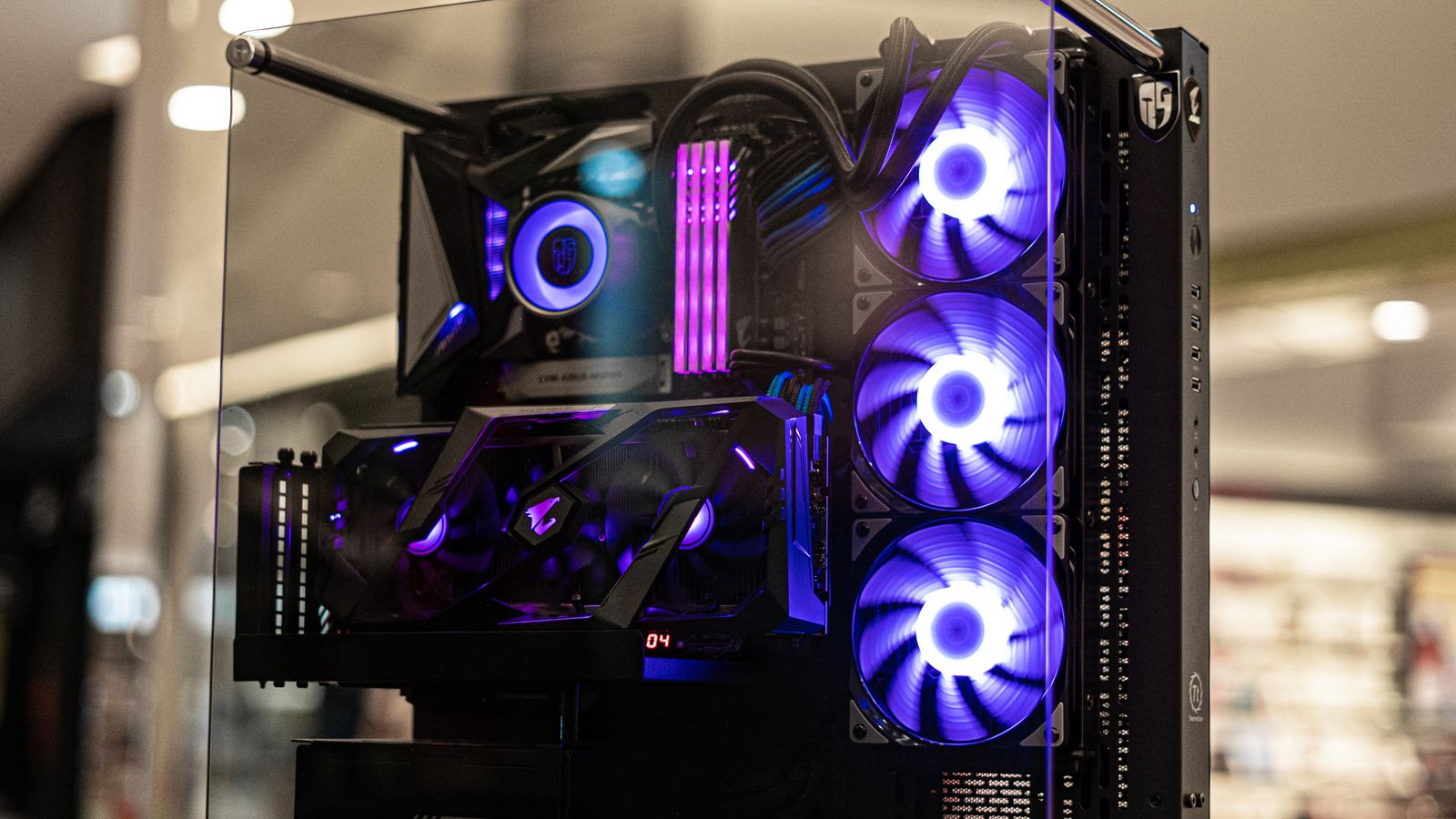 A gaming PC build with RGB cooling fans visible through a tempered glass case