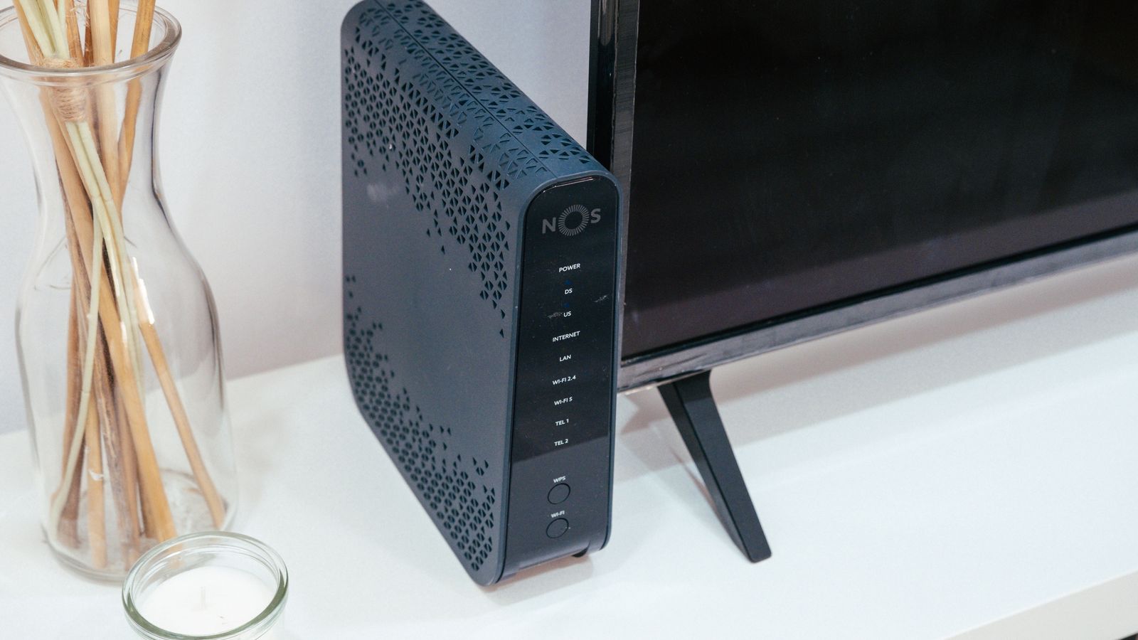 A typical ISP-supplied router and modem next to a television