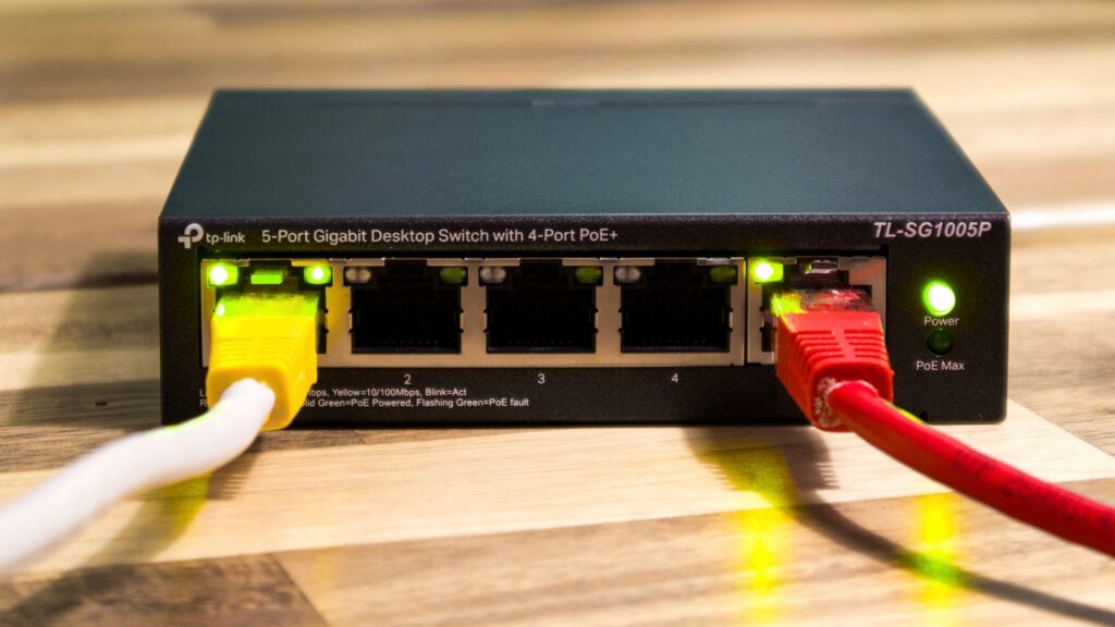 A TP-Link 5-port gigabit PoE network switch with ethernet cables connected