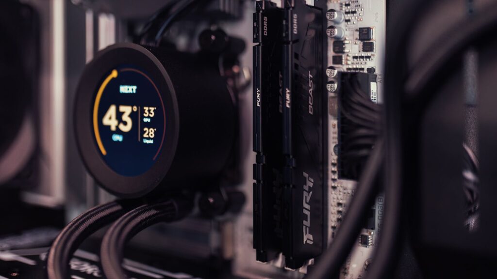 Two Kingston FURY Beast DDR5 sticks installed on a motherboard beside an AIO cooler