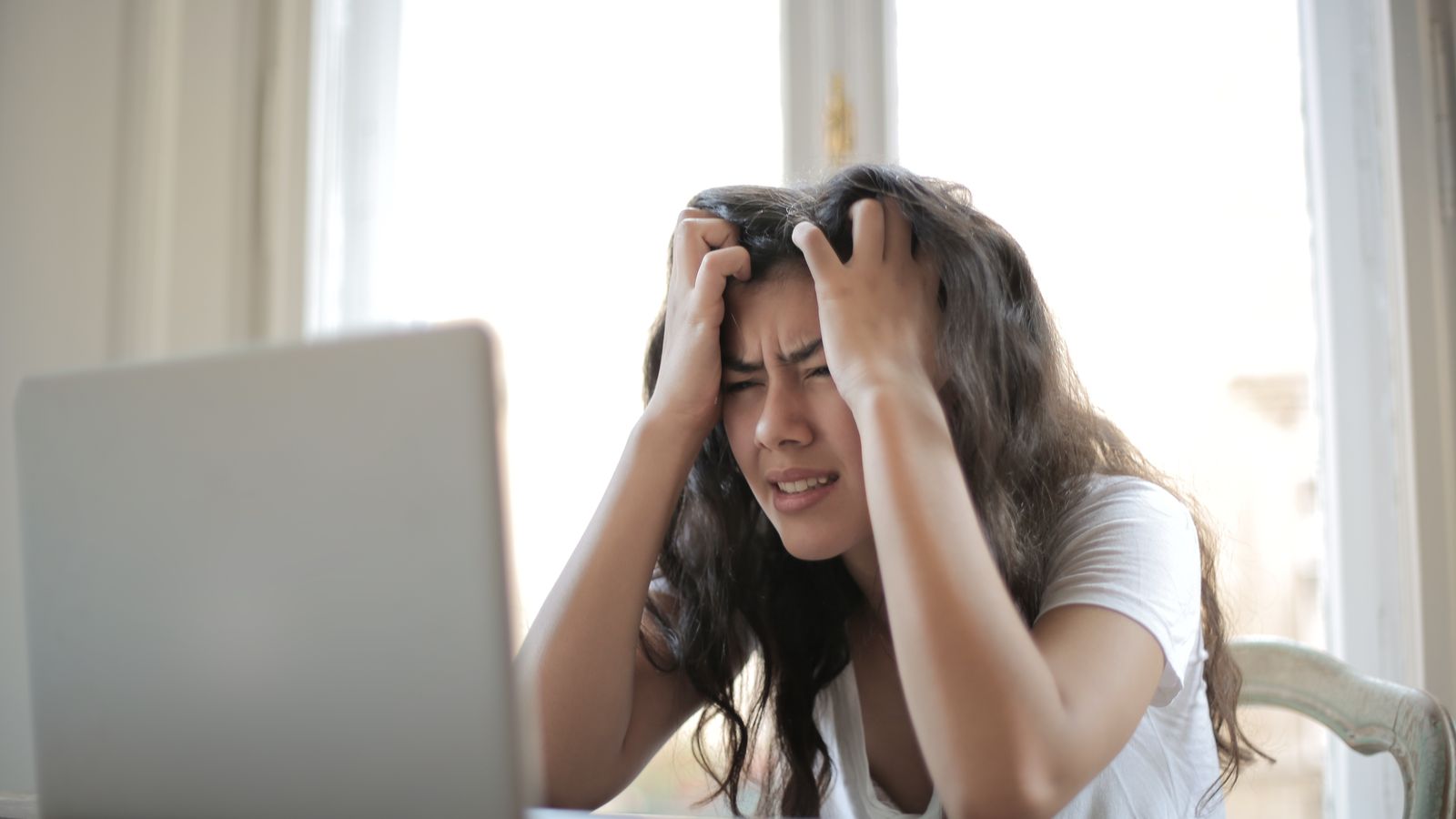 How to Fix a Slow Computer in 2026: The Real Causes (and the Fixes Most Guides Miss) | Hardvance Person holding their head in frustration at a slow laptop