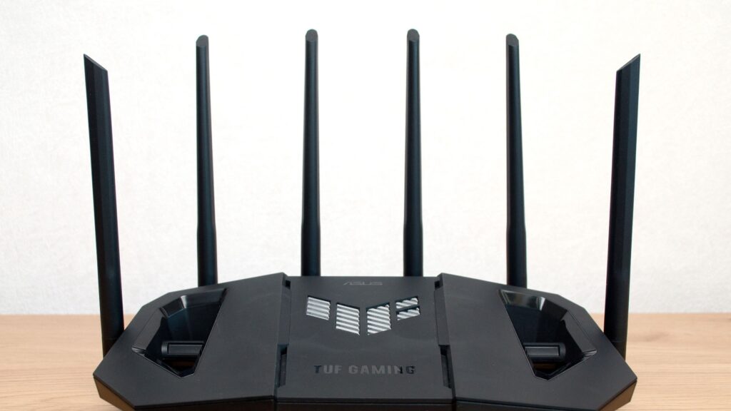 ASUS TUF Gaming Wi-Fi 7 router with six antennas on a wooden desk