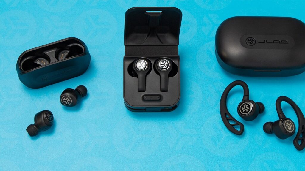 Three pairs of JLab true wireless earbuds with their cases on a blue background