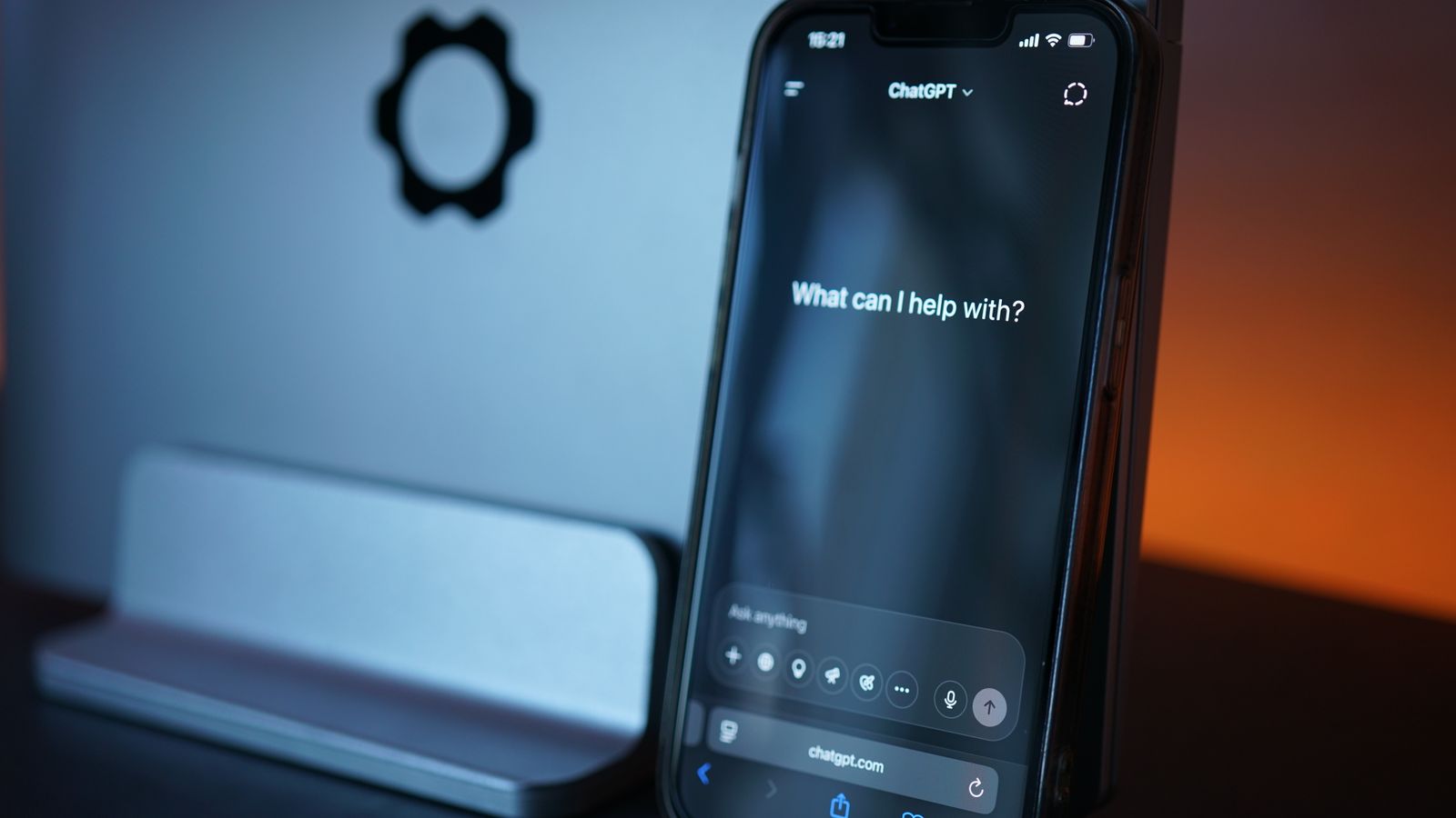 ChatGPT app open on a smartphone propped against a laptop