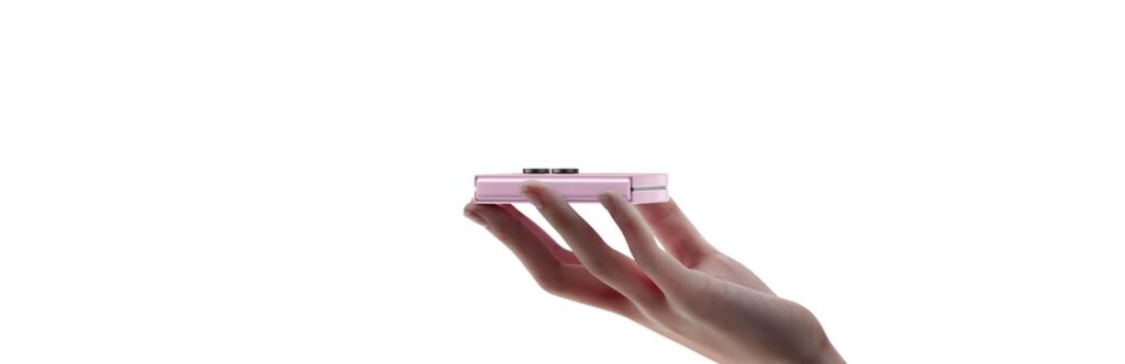 A pink Galaxy Z Flip8 folded shut resting on someone's fingers