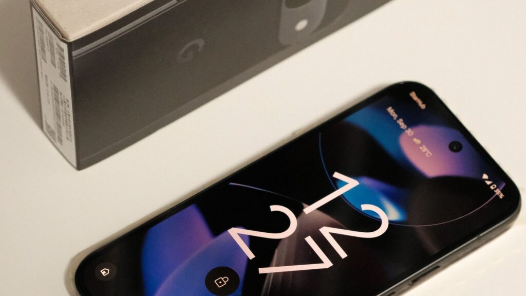 A Google Pixel smartphone next to its retail box on a white surface