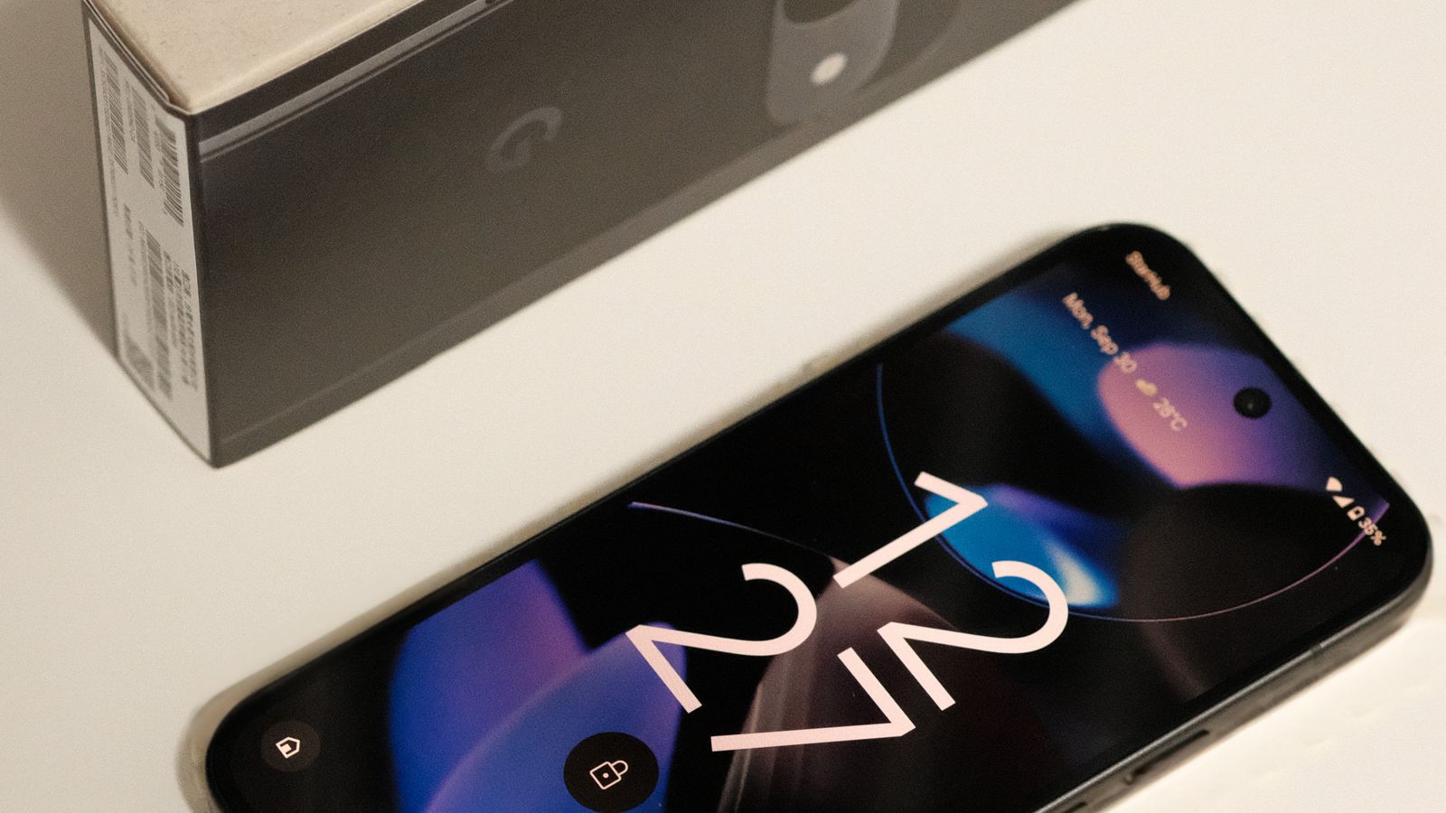 A Google Pixel smartphone next to its retail box on a white surface