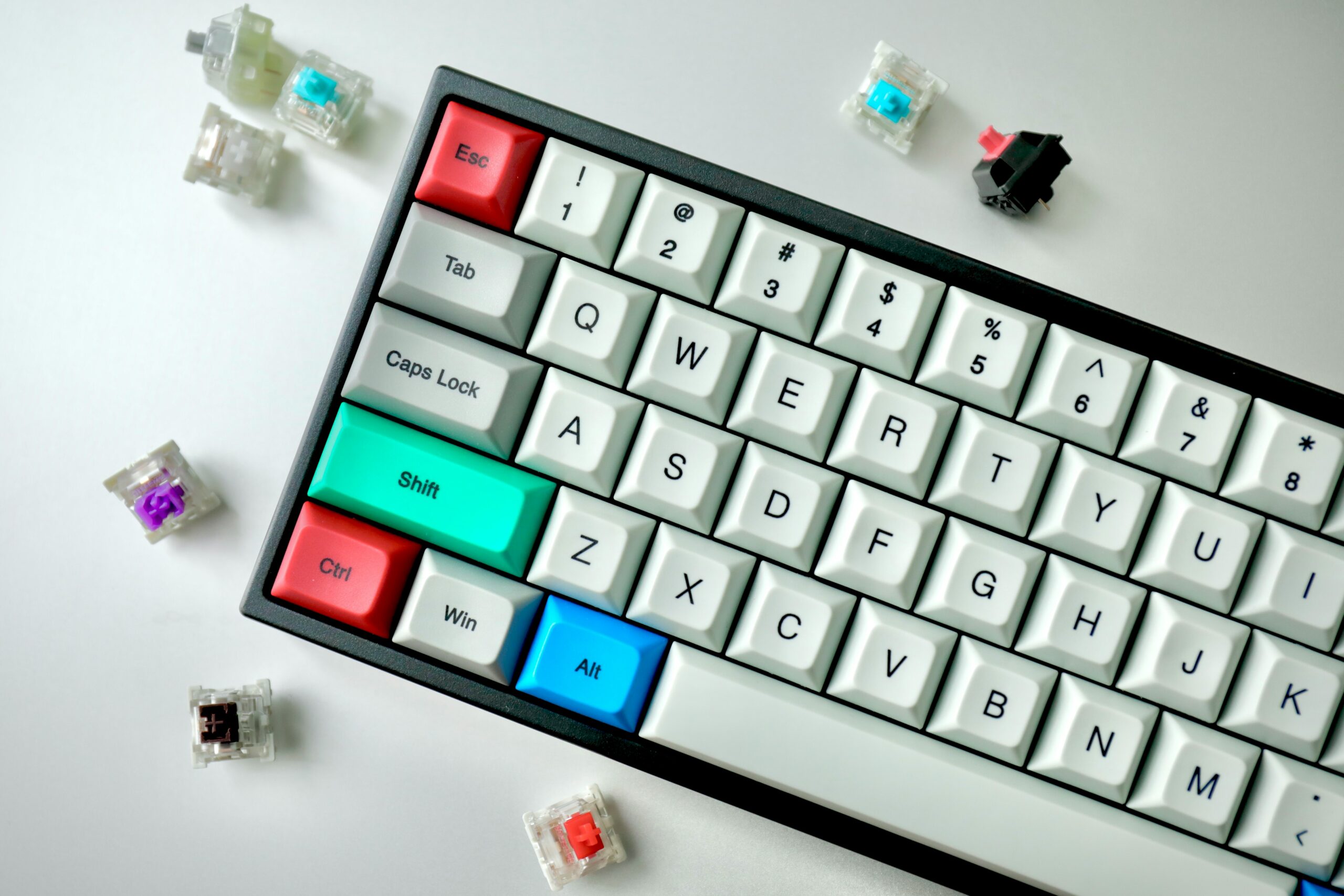 A mechanical keyboard surrounded by loose switches in various colours