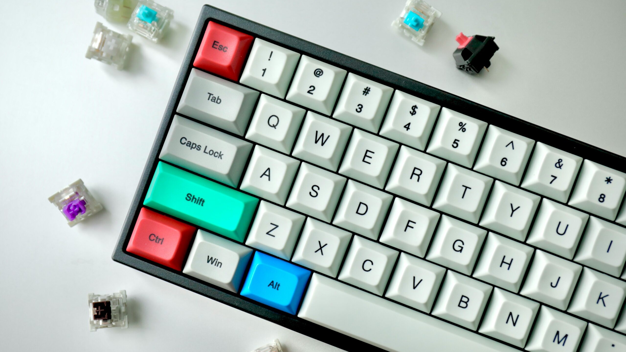Mechanical keyboard with coloured keycaps surrounded by loose key switches