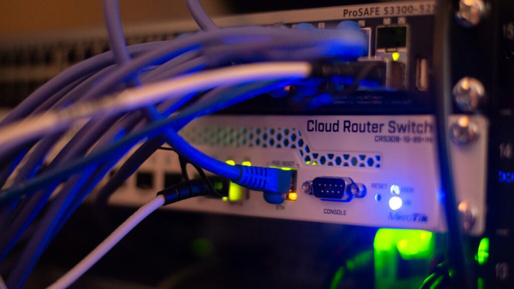 Close-up of a network router switch with glowing blue cables in a rack