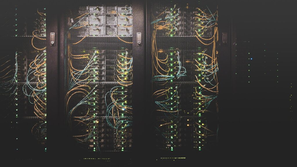 Dark server racks with glowing status lights and cables in a data center