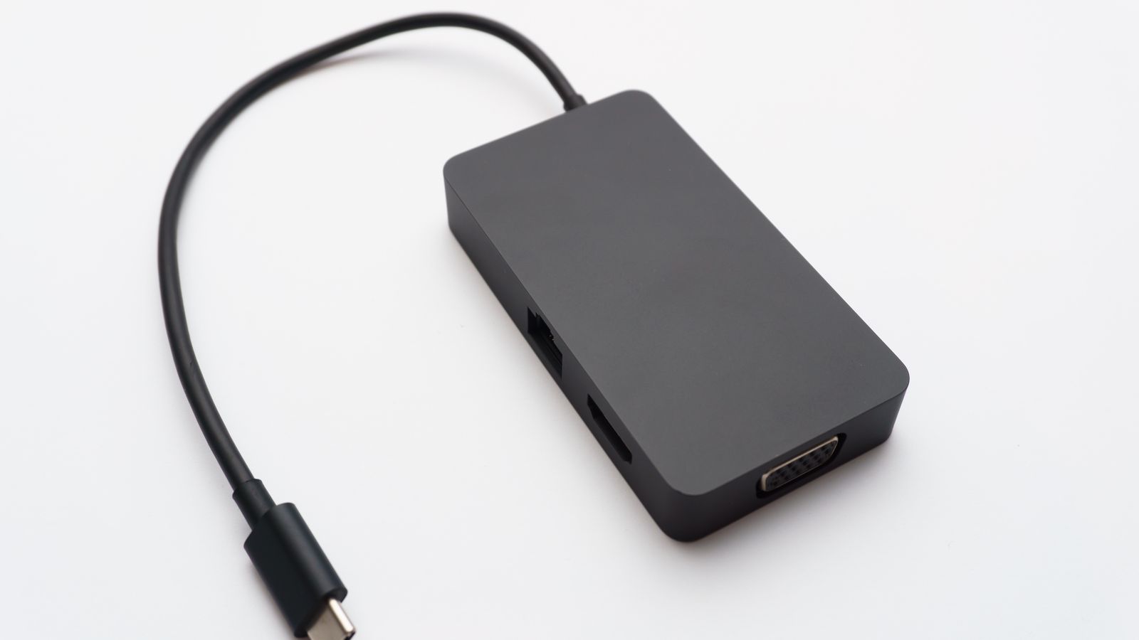 A black USB-C hub with HDMI, Ethernet and VGA ports and a USB-C connector cable