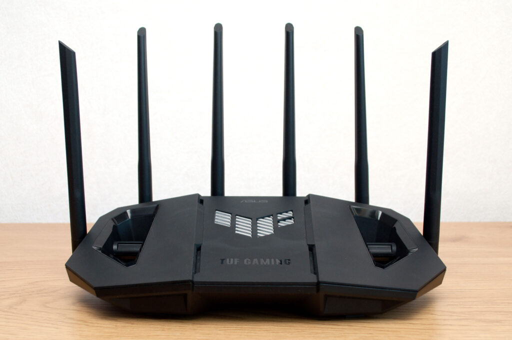 ASUS TUF Gaming WiFi 7 router with six antennas on a wooden desk
