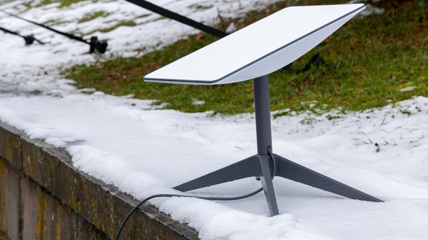 A Starlink dish on its stand surrounded by snow