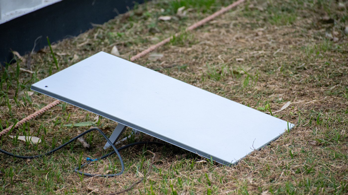 A Starlink standard dish resting on grass on its kickstand