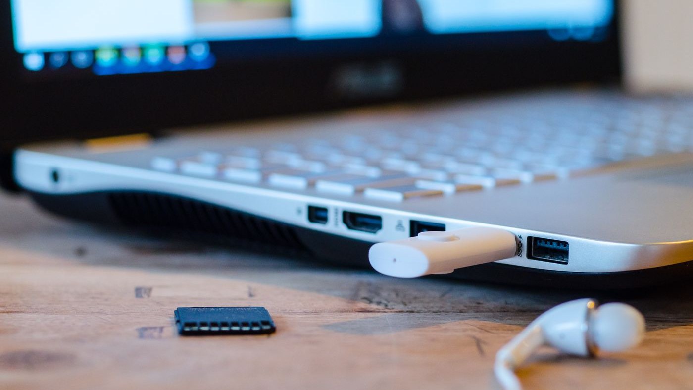 A USB stick plugged into the side of an Asus Windows laptop