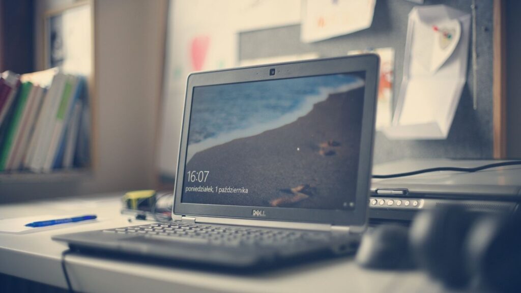 A Dell laptop on a desk showing the Windows lock screen