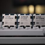 Three AMD Ryzen desktop processors, a 7700X, 9700X and 7800X3D, standing on a keyboard