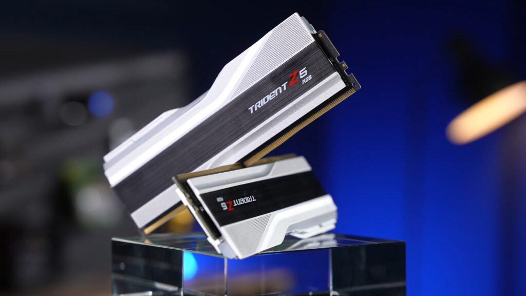 Two white G.Skill Trident Z5 RGB DDR5 memory sticks, G.Skill's Intel XMP series, on a glass stand