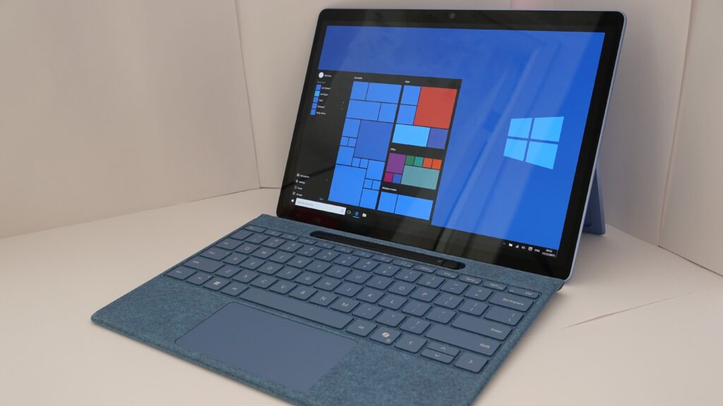 Microsoft Surface Pro with a blue keyboard cover and kickstand, showing the Windows Start screen
