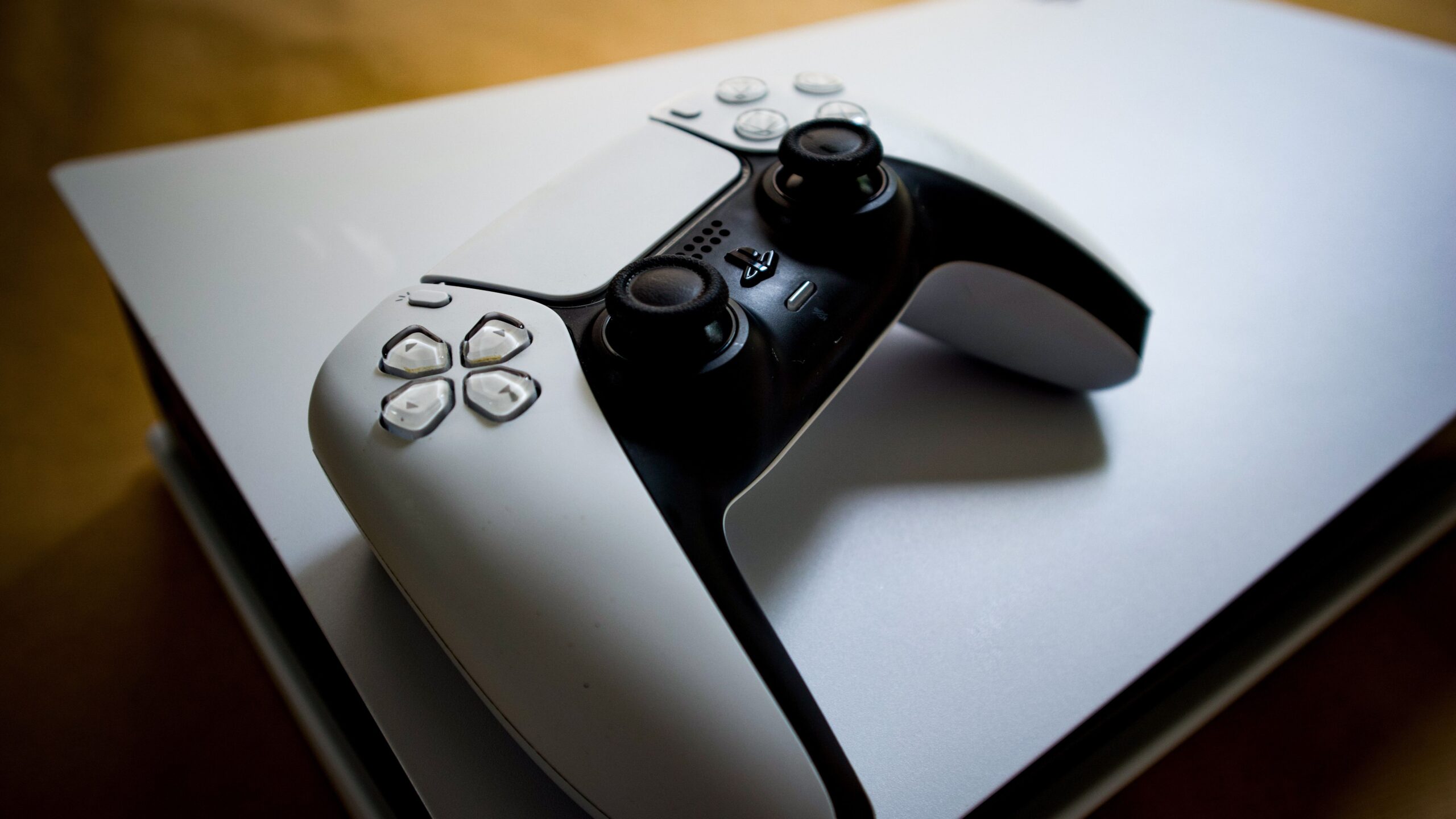White DualSense controller lying on top of a PS5 console