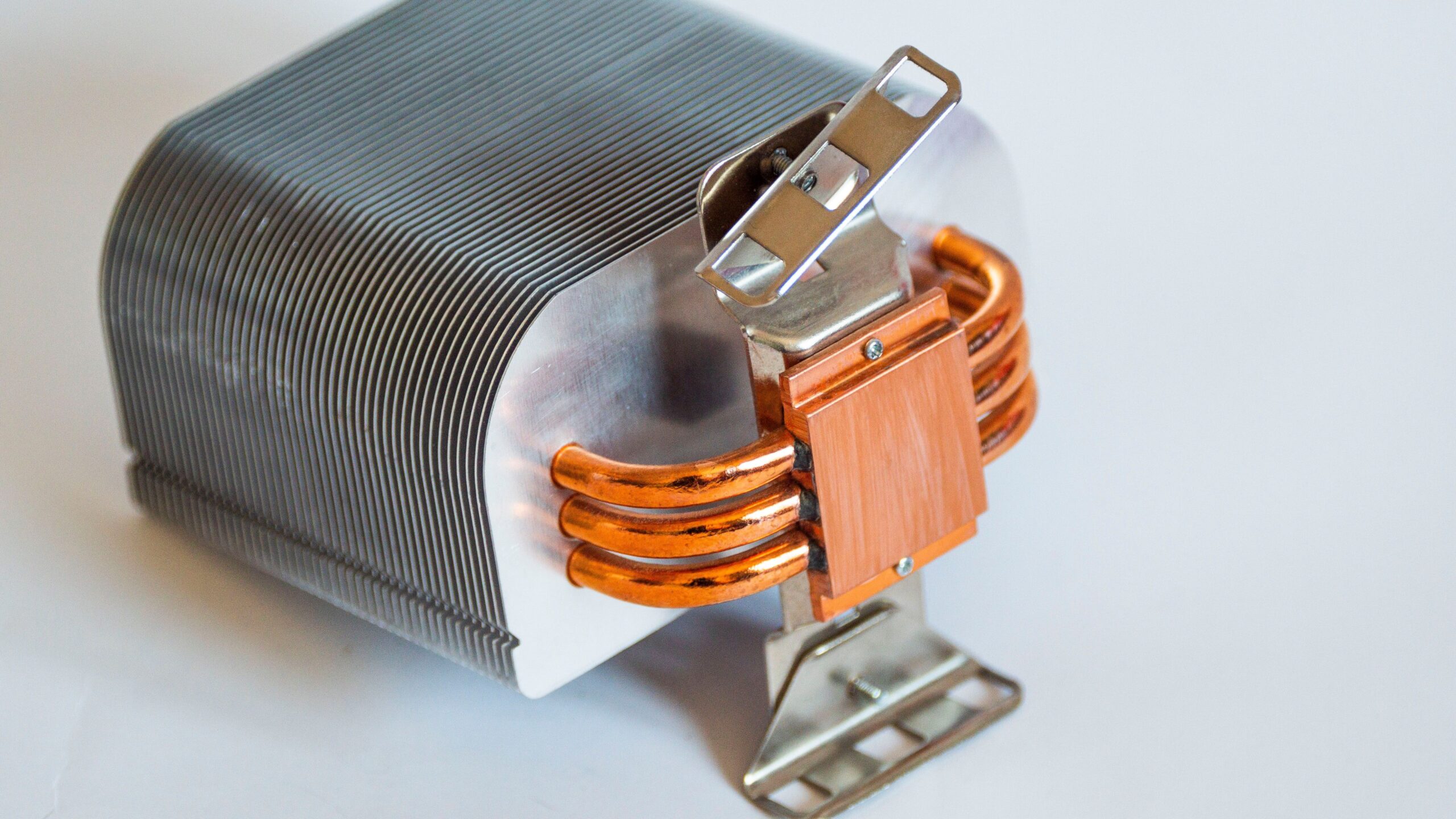 Bare CPU air cooler heatsink with aluminium fins and copper heat pipes on a white background