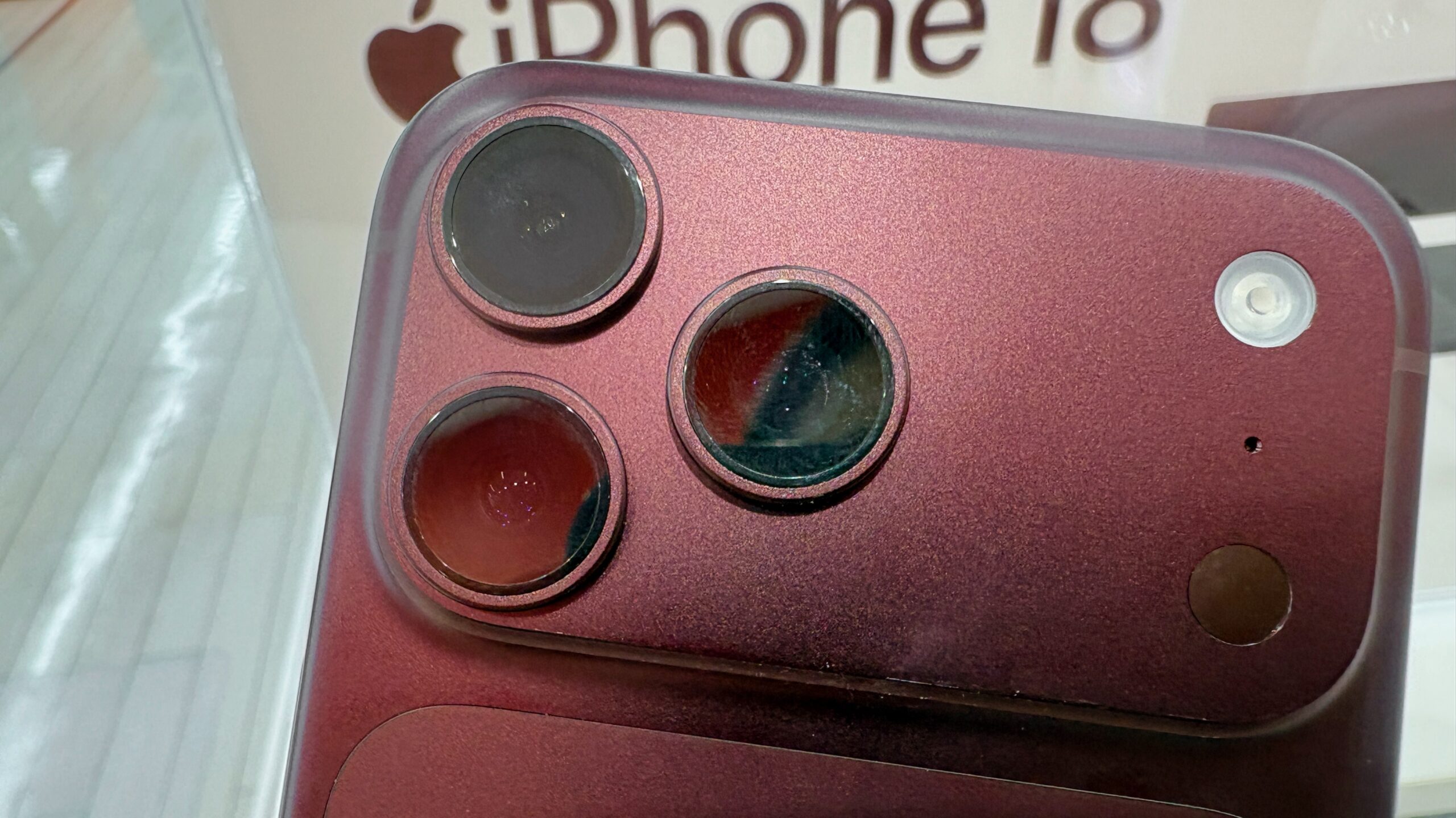 Close-up of the three rear cameras and flash on a burgundy iPhone 18 Pro Max