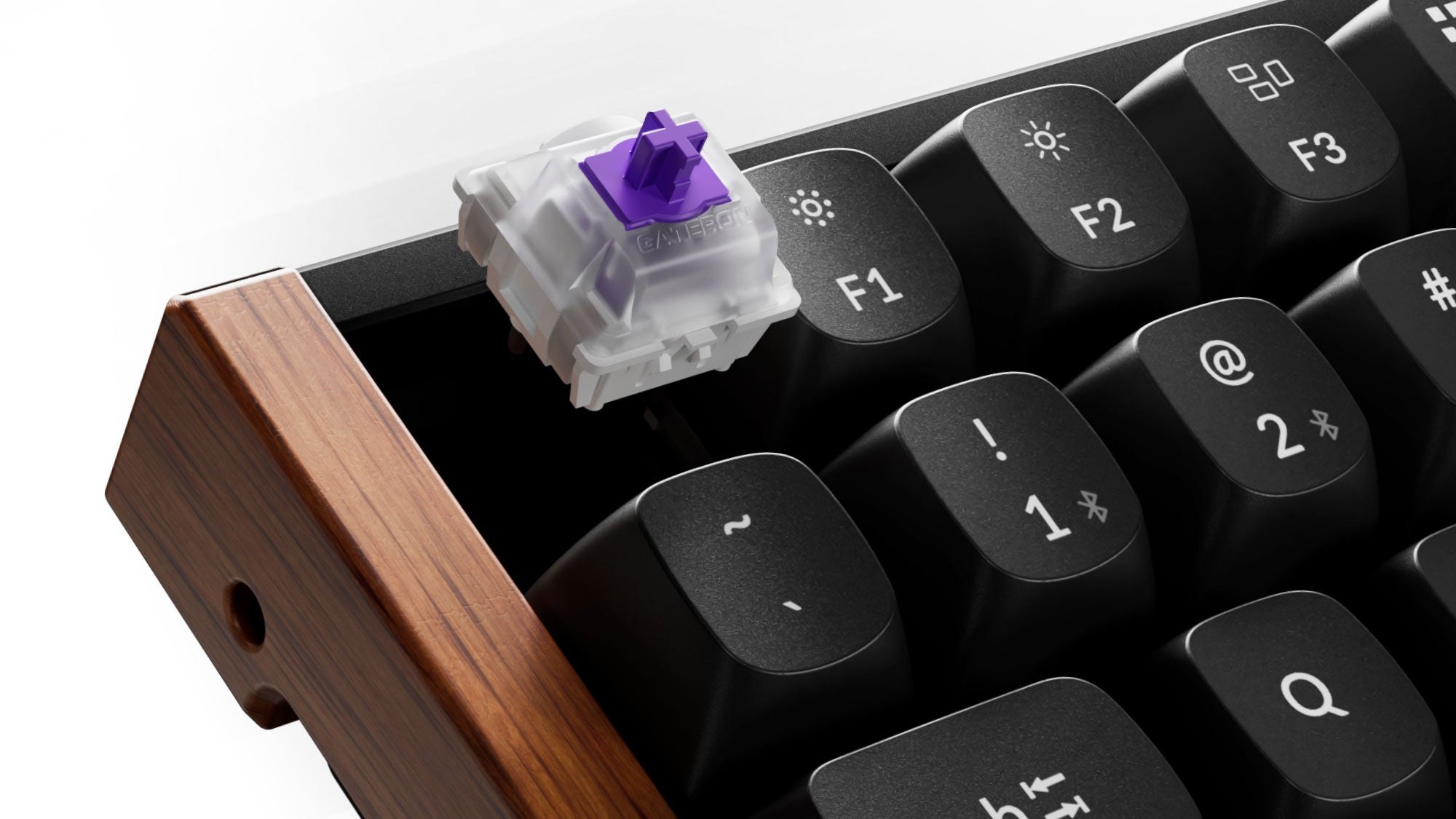 A Gateron double-rail magnetic switch lifted out of a black Keychron K2 HE with a wood side panel