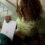 Person taking a silver MacBook Air M5 out of a green backpack on a stairway
