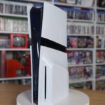 PS5 Pro console standing upright on a turntable in front of shelves of video games