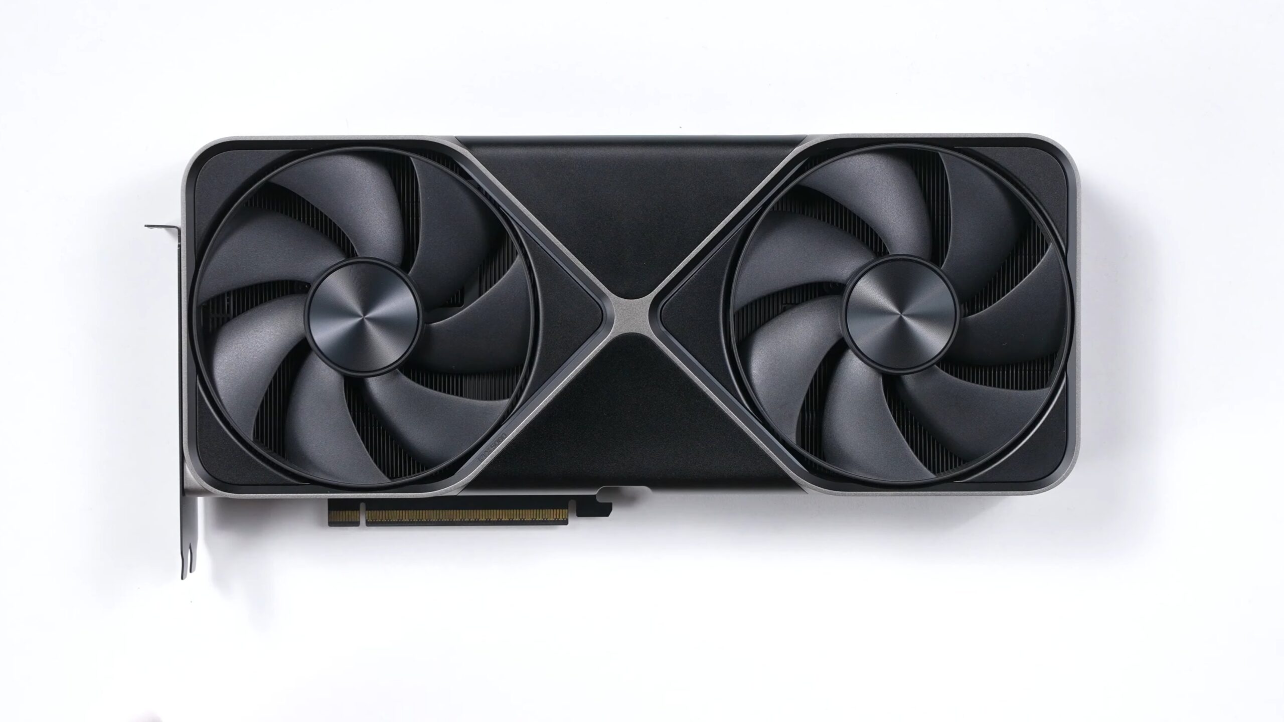 NVIDIA GeForce RTX 5080 Founders Edition graphics card with two fans, lying on a white surface