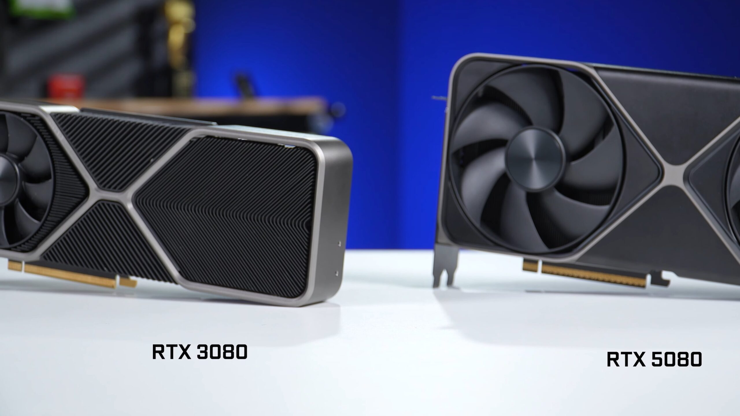 An RTX 3080 Founders Edition next to an RTX 5080 Founders Edition on a white desk
