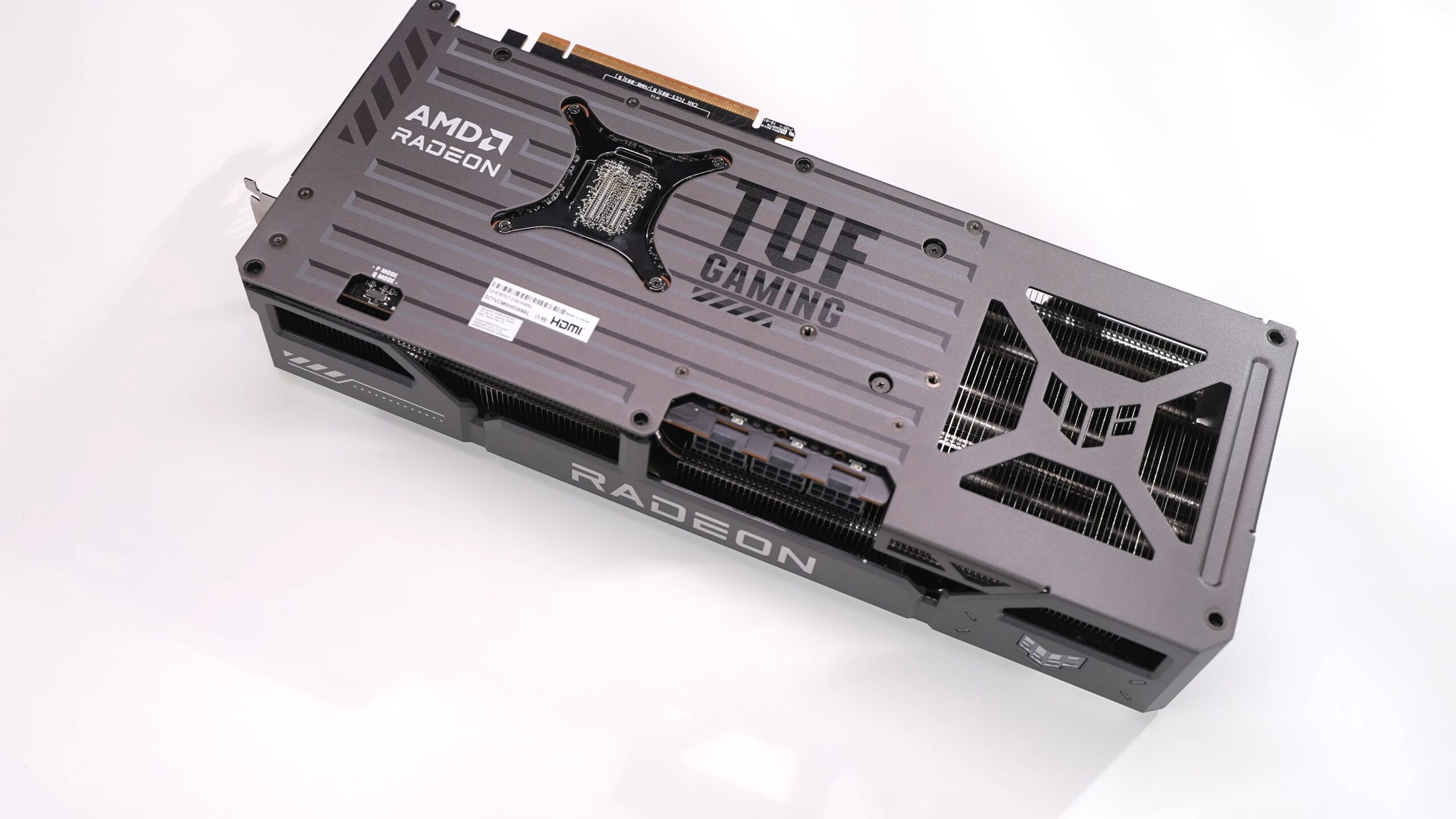 The backplate of an ASUS TUF Gaming Radeon RX 9070 XT graphics card on a white surface